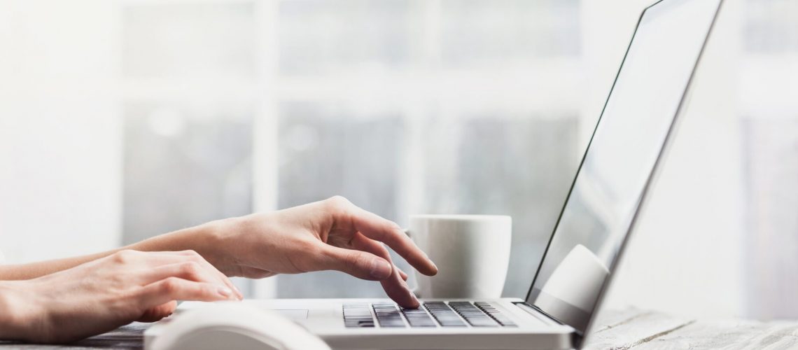 Close-up of female hands on laptop computer keyboard